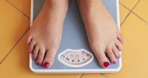 woman's feet on bathroom scale