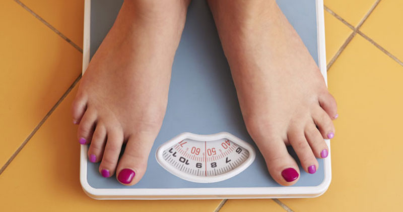 woman's feet on bathroom scale