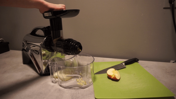 person putting apple slices into omega nc900hdc juicer
