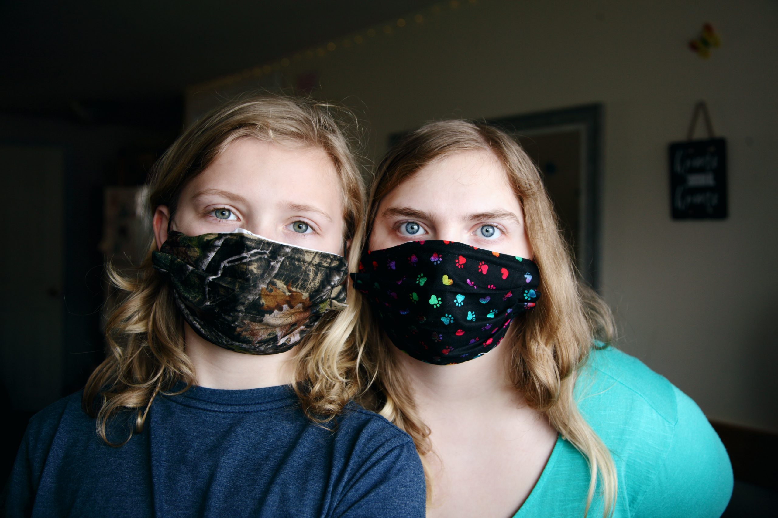 two young girls wearing cloth masks